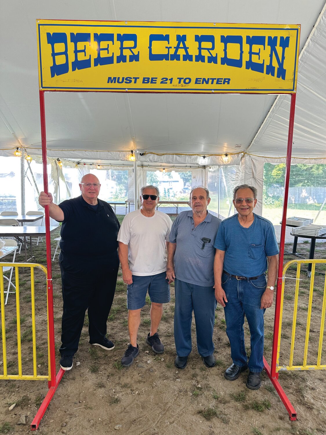 HELPING HANDS: OLG Pastor Rev. Peter J. Gower joins and thanks Biagio Micheletti, Mecca Domenico and Louie Raso for their help last week when the Beer Garden was set up under the now 600-seat big top.